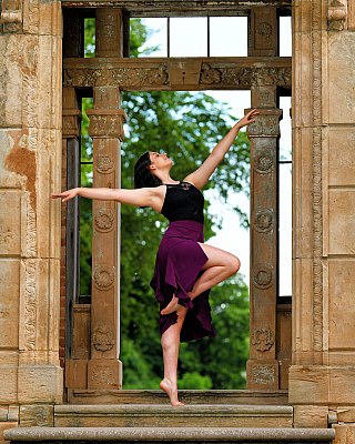 senior picture of louisville kentucky graduate. girl in purple dress doing a ballet pose