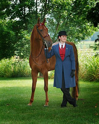 senior photography of louisville kentucky graduate. teenage girl wearing equestrian clothing, standing next to brown horse