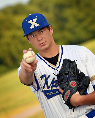 senior photography of louisville kentucky graduate. teenage boy in baseball uniform holding out baseball with black baseball glove