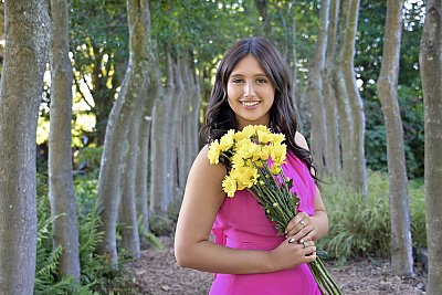 senior photography of louisville kentucky graduate. teenage girl in pink dress posing while holding yellow flowers