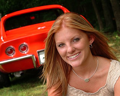 senior photography of louisville kentucky graduate. girl with red hair posing in front of her red sports car