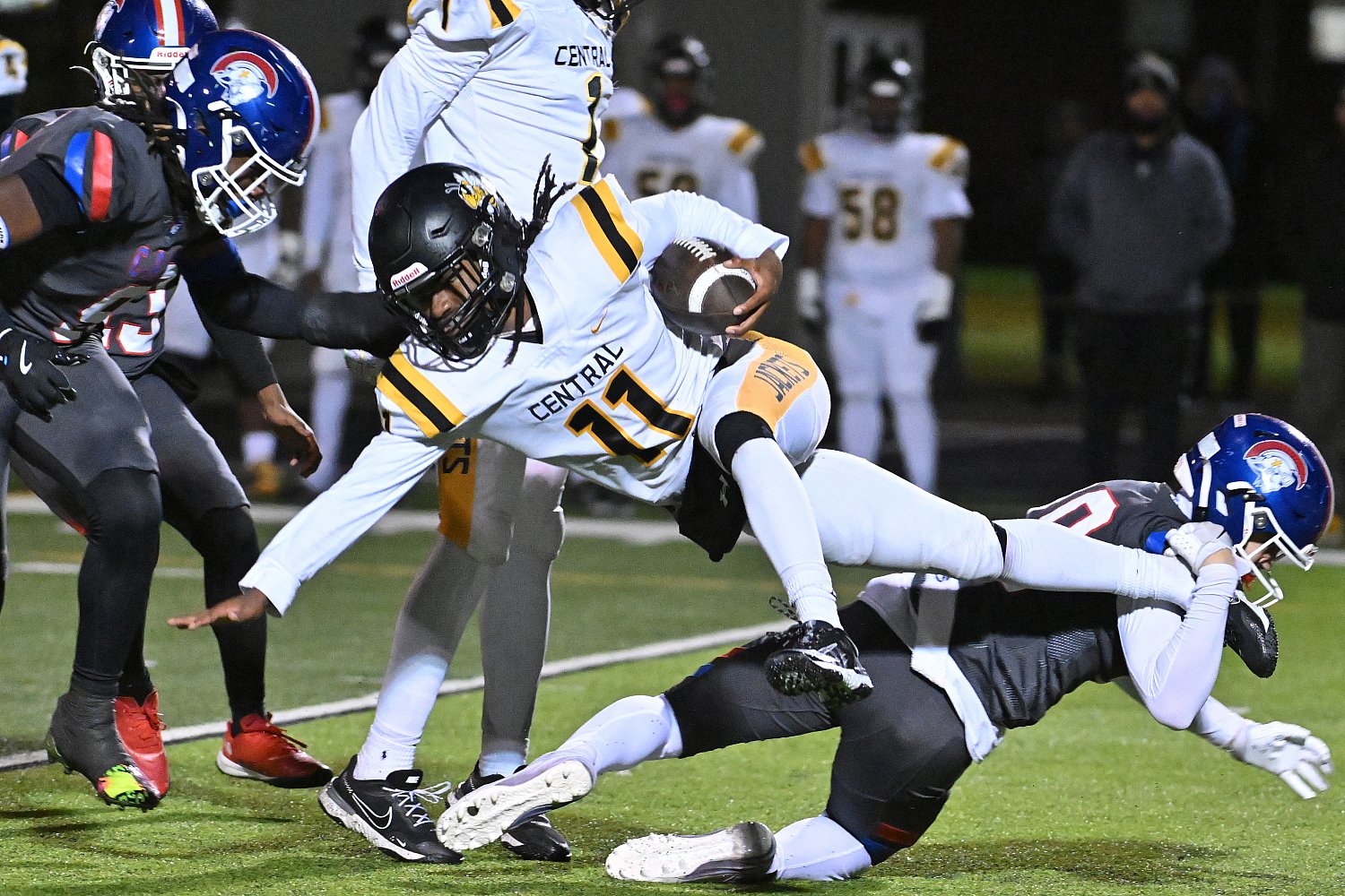 action photo of football player being tackled while holding football